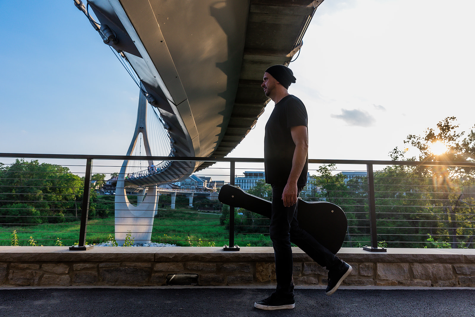 Eric Z walking with a guitar case